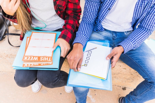 high-angle-view-male-female-student-planning-weekly-schedule
